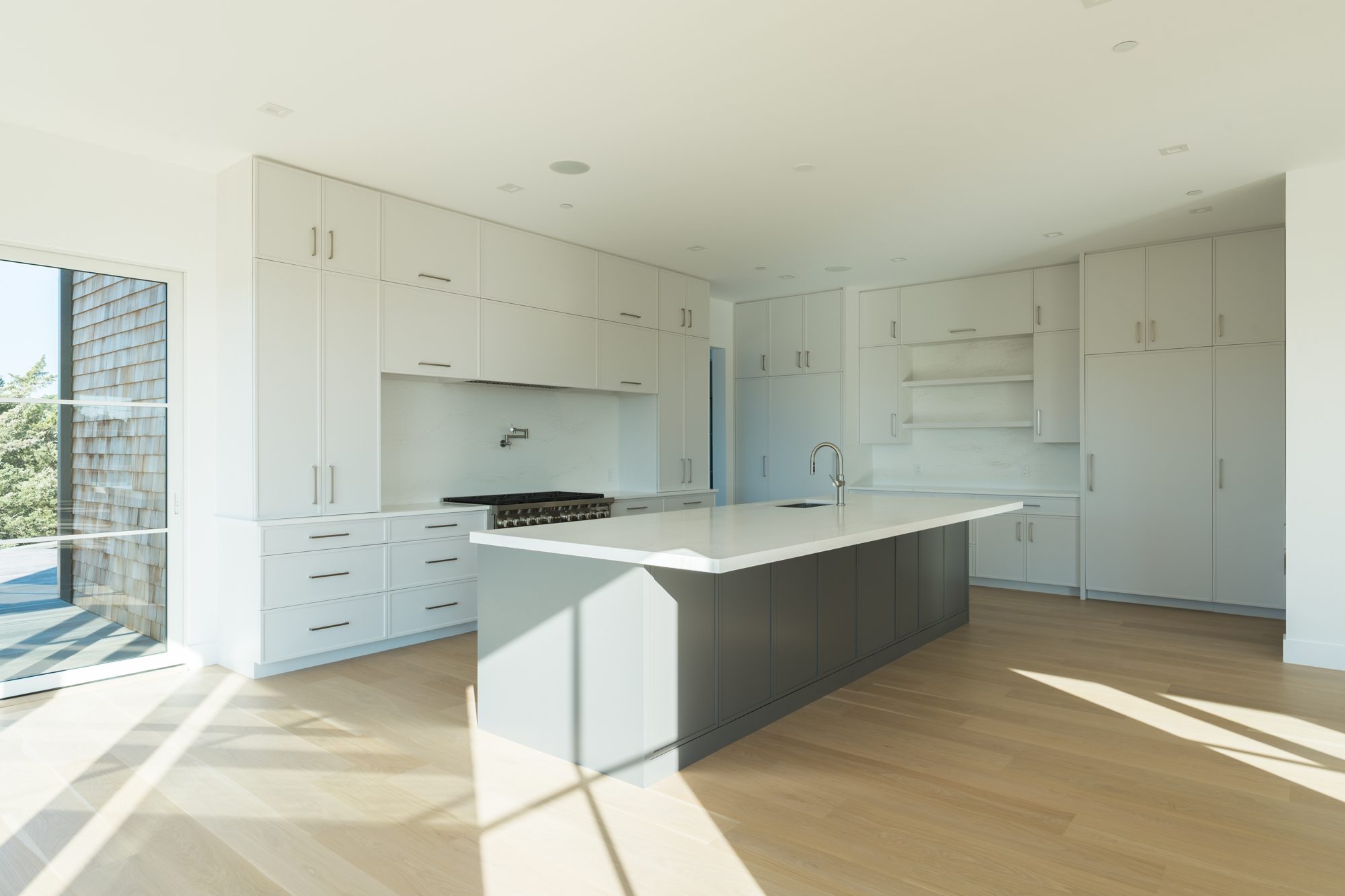 White kitchen with island and oak floors