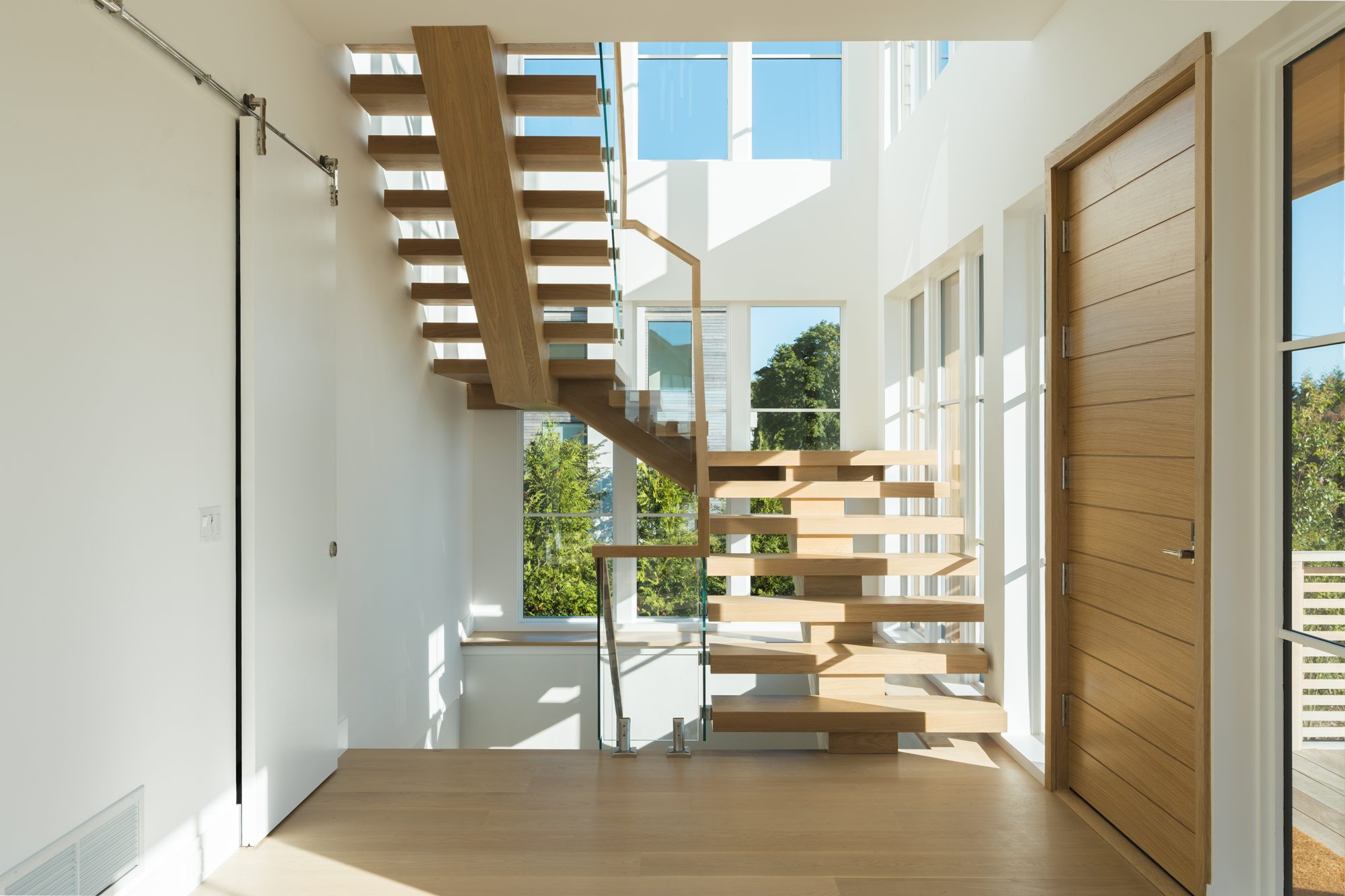 Double-height stair hall with open oak treads
