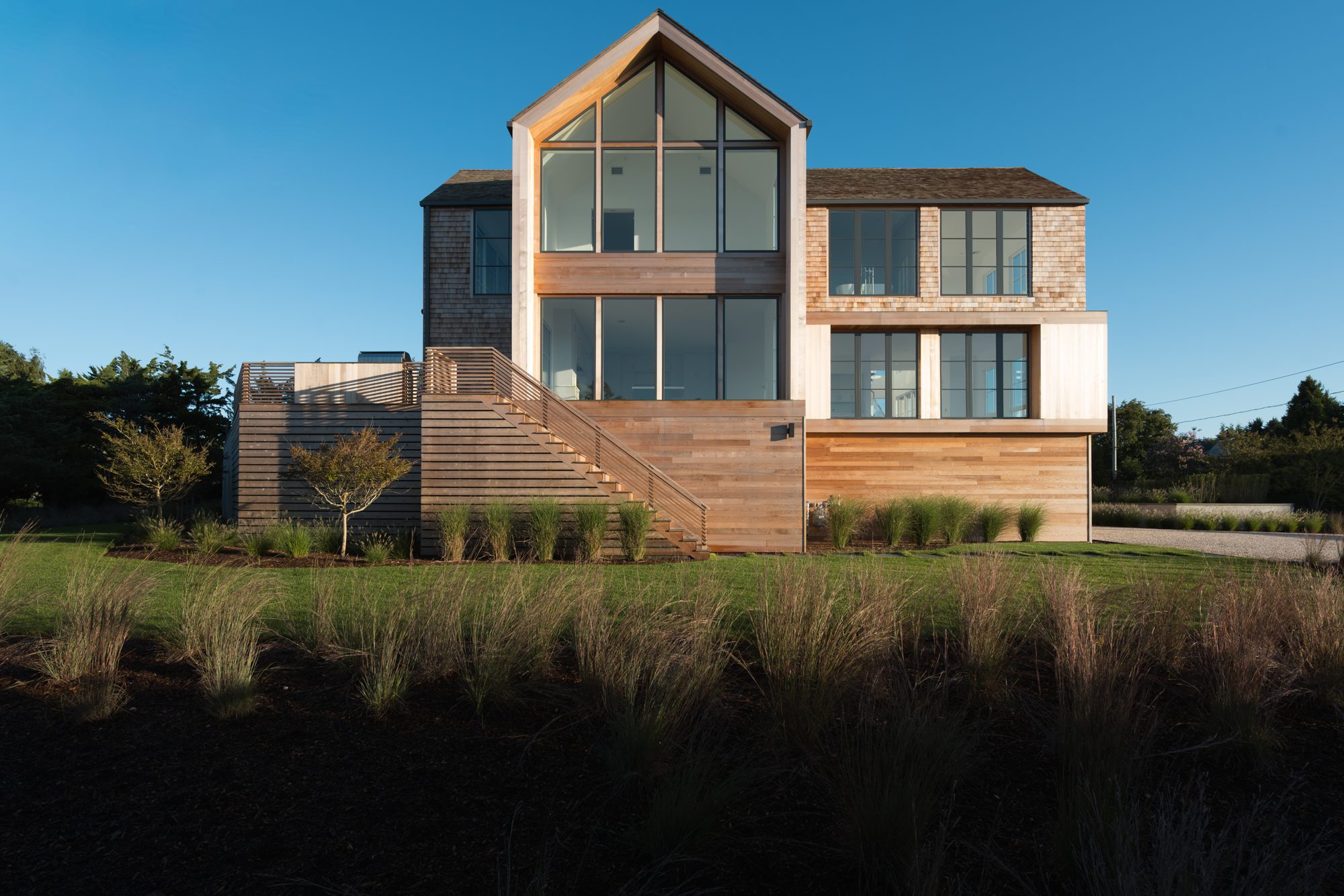 Gabled glass facade and exterior stair at the rear