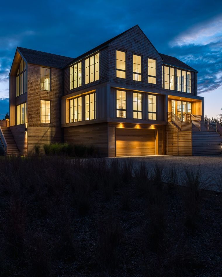 Shingled house glowing from within at dusk