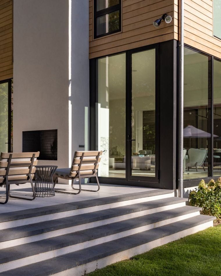Glass-walled corner and outdoor fireplace terrace with lounge chairs